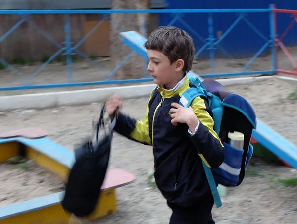 男孩用背包行走模糊运动图像，脸上的焦点 — 图库照片