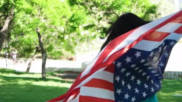 Patriótica jovem com a bandeira americana realizada em suas mãos dançando lentidão — Vídeo de Stock