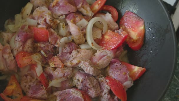 Varkensvlees meet en tomaten in pan. — Stockvideo