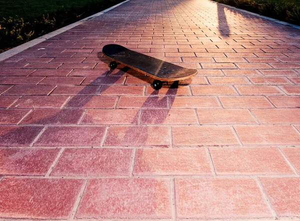 Vintsge skateboard σε πλακόστρωτα επιφάνεια με οπίσθιο φωτισμό. Τονισμένο εικόνας — Φωτογραφία Αρχείου