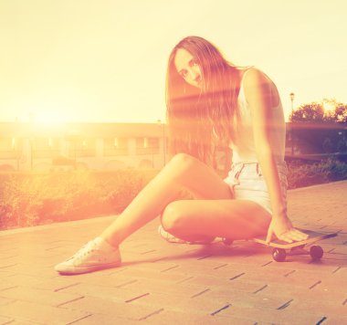 Renk tonlu görüntü og genç kız onun kaykay üzerinde oturan