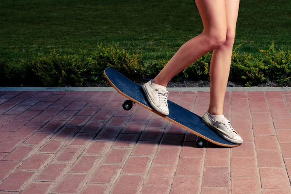 Jonge vrouwen doen een truc op een skateboard — Stockfoto