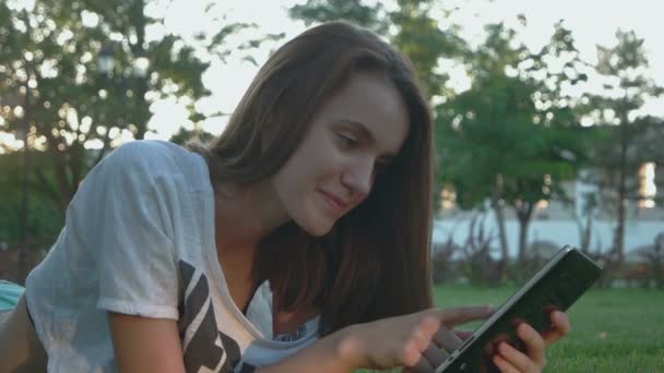 Bastante adolescente chica está trabajando en internet al aire libre — Vídeos de Stock