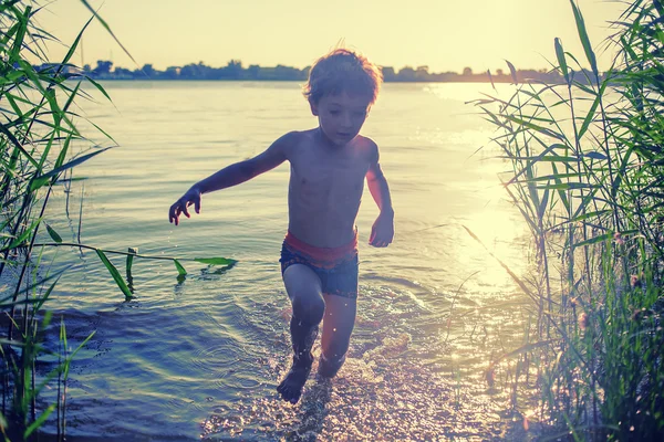 Счастливый мальчик выбегает из воды — стоковое фото