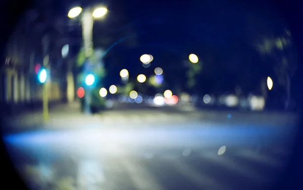 Blurred street at night time. Vintage looking shot made with old lens