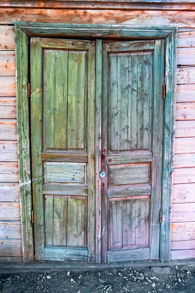 Old door painte in green and blue color, weathered architectural detail in Astrakhan, Russia