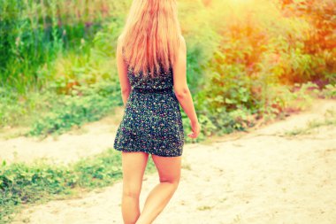 Uzun saçlı kız kum üzerinde yürüyüş arka görünümü