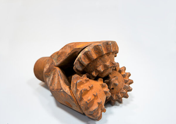 Используемая головка для бурения нефти на сером фоне
