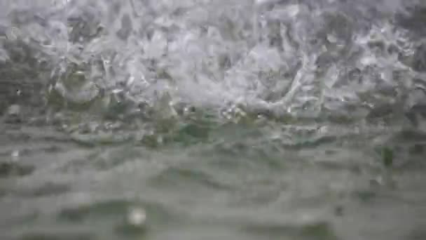 Water spatten over wateroppervlak — Stockvideo