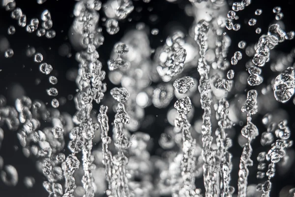 Gocce di acqua levitazione su sfondo nero, macro immagine. Acqua congelata  . — Foto Stock