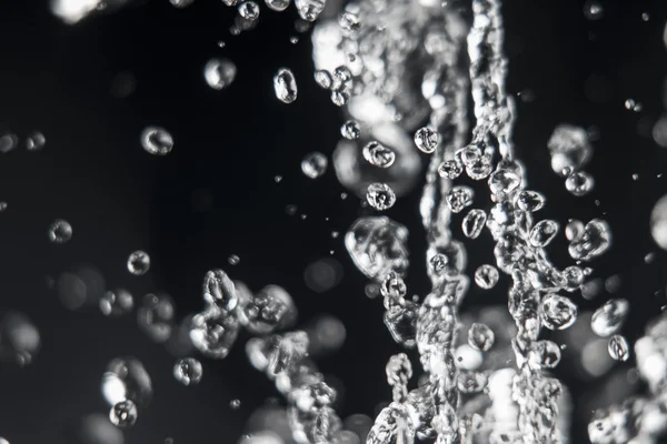Gotas de agua levitando con gotas desenfocadas en el fondo — Foto de Stock