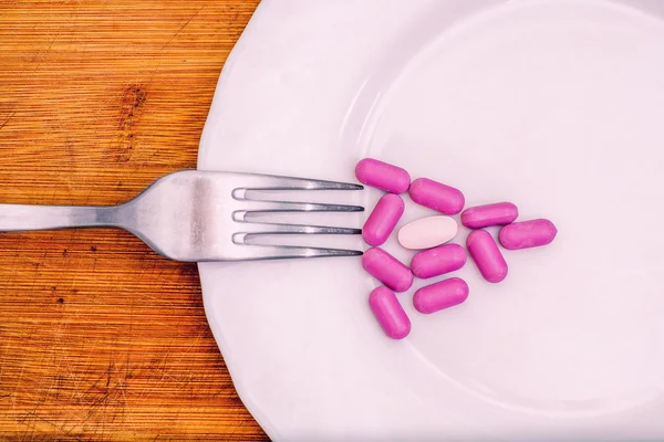 Pillole rosa sotto forma di pizza triangolo, concetto di dieta — Foto Stock