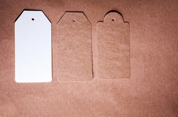 Tiga lembar kertas dengan bentuk yang berbeda pada latar belakang kertas kerajinan — Stok Foto