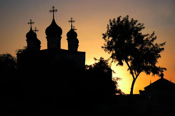 Igreja ortodoxa e silhueta de bétula ao pôr do sol — Fotografia de Stock