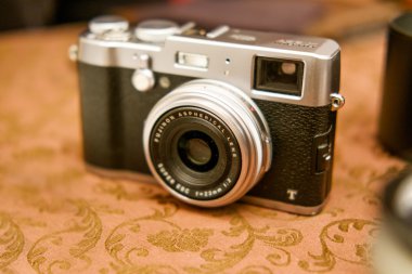 Astrakhan, Rusya - 07 Aralık 2015: Fujifilm X 100 aynasızlar dijital kamera antika arka plan üzerinde. Fujifilm teknolojik aynasızlar kamera pazarında liderdir