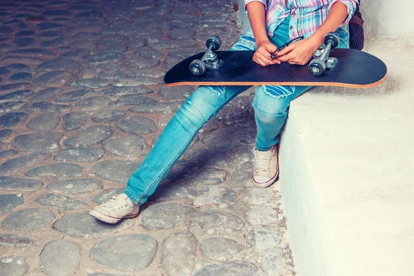 Fille avec échateboard sur ses genoux et copyspace — Photo