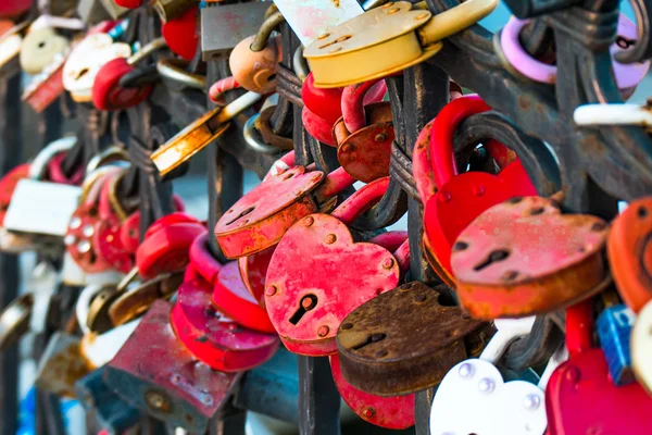 Fechaduras de amor na forma de coração pintado de cor vermelha na ponte — Fotografia de Stock