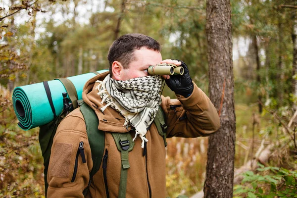 Mann mit Fernglas im Wald Stockbild