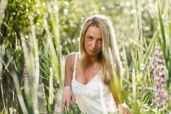 잔디 클로즈업에 금발의 젊은 여자 — 스톡 사진