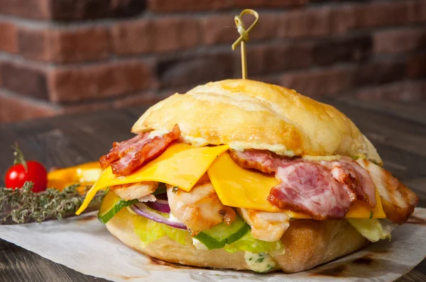 Burger mit Fleisch, Tomaten, Zwiebeln, Käse, Salat, Gemüse auf Holztisch — Stockfoto