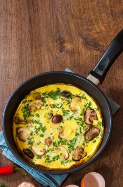 ahşap masa üzerinde bir tavada mantarlı omlet
