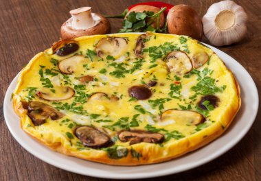 ahşap masa üzerinde bir tabak mantarlı omlet