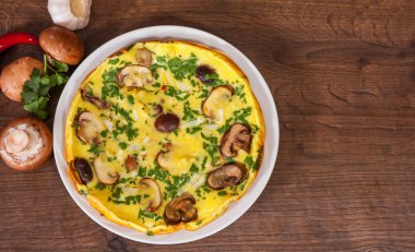 ahşap masa üzerinde bir tabak mantarlı omlet