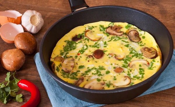 Omlett gombával, egy serpenyőben, a fából készült asztal — Stock Fotó