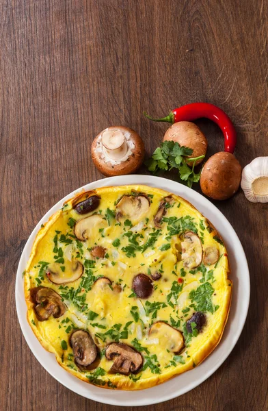 ahşap masa üzerinde bir tabak mantarlı omlet