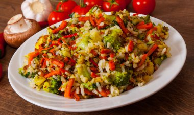 Ahşap masa bir tabağa pilav ile karışık sebze