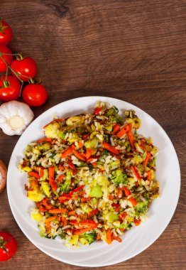 Ahşap masa bir tabağa pilav ile karışık sebze