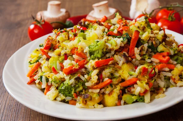 Ανάμικτα λαχανικά με ρύζι σε ένα πιάτο στο ΤΡΑΠΕΖΙ ΞΥΛΙΝΟ — Φωτογραφία Αρχείου
