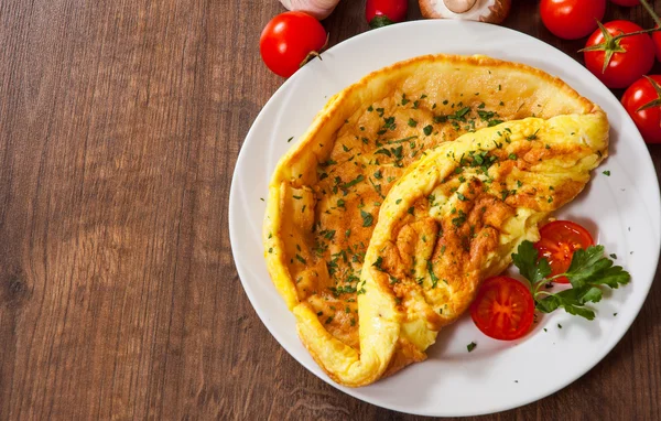 Omelette dans une assiette sur une table en bois — Photo