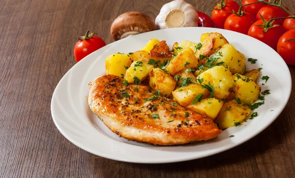 Grilled chicken breast with potato in a plate on wooden table — Stock Photo, Image