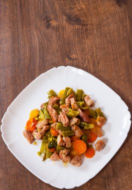 ahşap masa bir tabakta sebze ile haşlanmış et