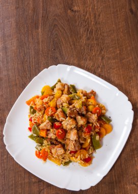 Pirinç sebze ve et ahşap masa üzerinde bir plaka ile