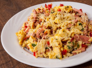 omlet jambon, sebze ve peynir bir plaka üzerinde ahşap masa