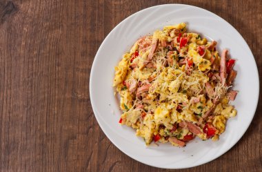 omlet jambon, sebze ve peynir bir plaka üzerinde ahşap masa