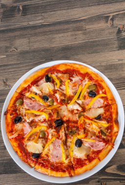 Ananas, jambon, tavuk, peynir, zeytin ve ahşap bir masa üzerinde sebze ile Hawai pizza