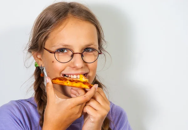 Mladá brunetka jíst kus pizzy na bílém pozadí. — Stock fotografie