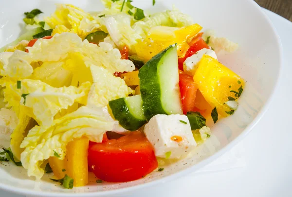 Salada vegetal com queijo, repolho, pimenta, tomate e pepino na mesa de madeira — Fotografia de Stock