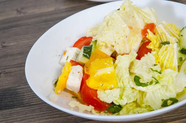 Insalata di verdure con formaggio, cavolo, pepe, pomodoro e cetriolo sul tavolo di legno — Foto Stock