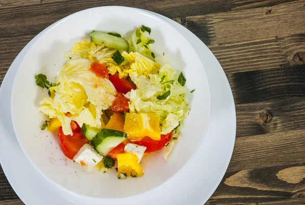 Insalata di verdure con formaggio, cavolo, pepe, pomodoro e cetriolo sul tavolo di legno — Foto Stock