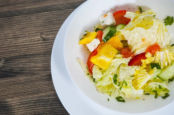 Salada vegetal com queijo, repolho, pimenta, tomate e pepino na mesa de madeira — Fotografia de Stock