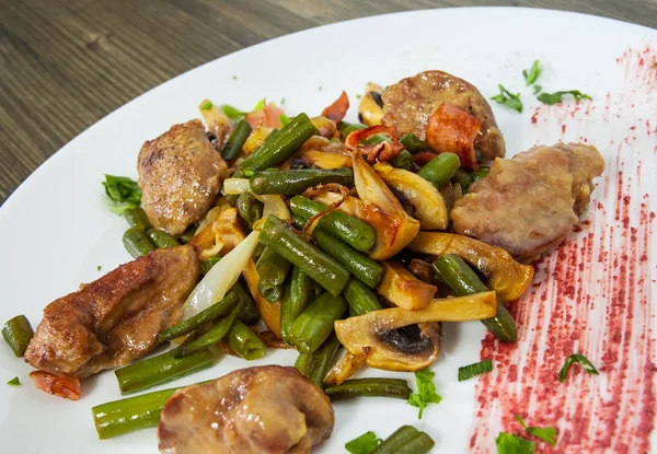 Fígado de frango com bacon, cogumelos e feijão verde na mesa de madeira — Fotografia de Stock