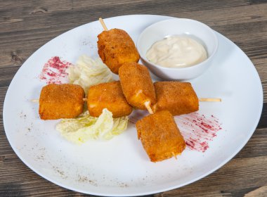 Kızarmış mozzarella peynirli çubuk soslu plaka üzerinde tava