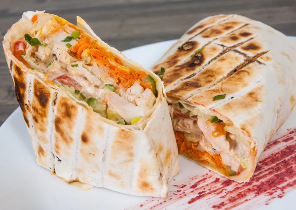 Shawarma in thin pita bread with chicken and vegetables on a plate — Stock Photo, Image