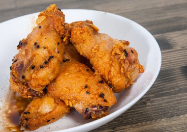 Soya sosu ve ahşap masa üstünde susam ile yapışkan Çin tavuk kanadı