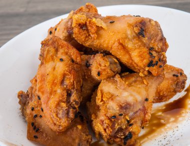Soya sosu ve ahşap masa üstünde susam ile yapışkan Çin tavuk kanadı