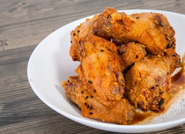 Soya sosu ve ahşap masa üstünde susam ile yapışkan Çin tavuk kanadı